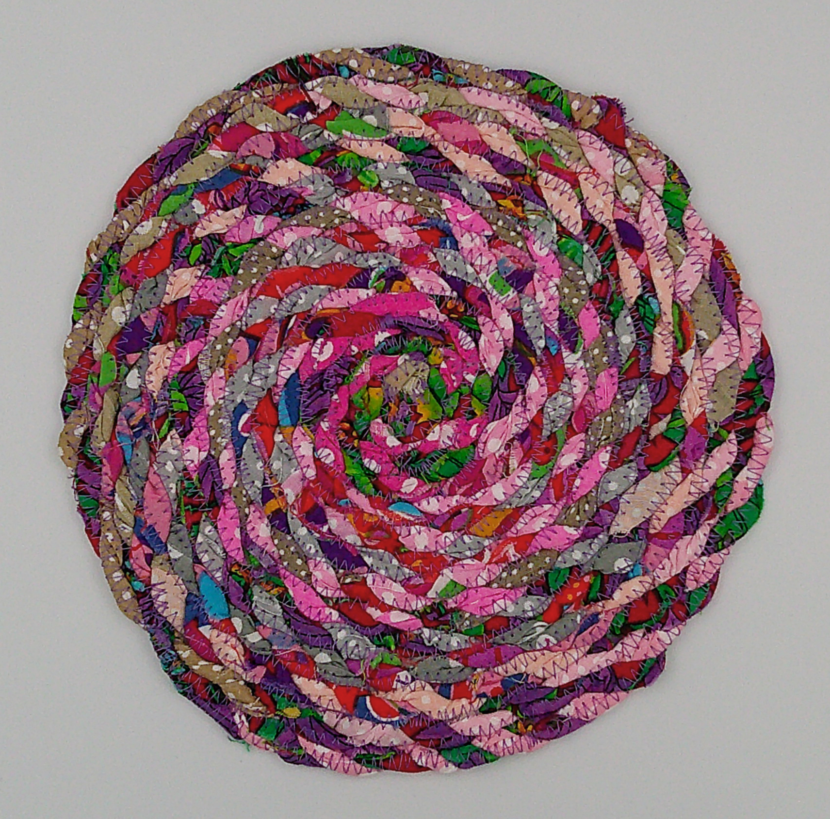 This vibrant multicolored trivet is approximately 8 inches round.  This vibrant multicolored trivet is approximately 8 inches round.